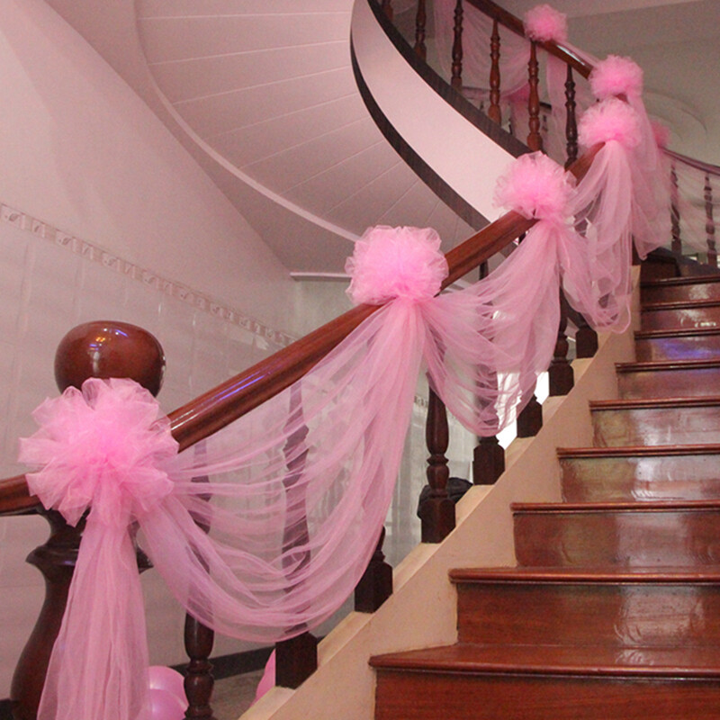 Dream bridge wedding room is decorated with wedding supplies. It is a beautiful pink suit with flower ball decoration on the arch of stair handrail in the new house